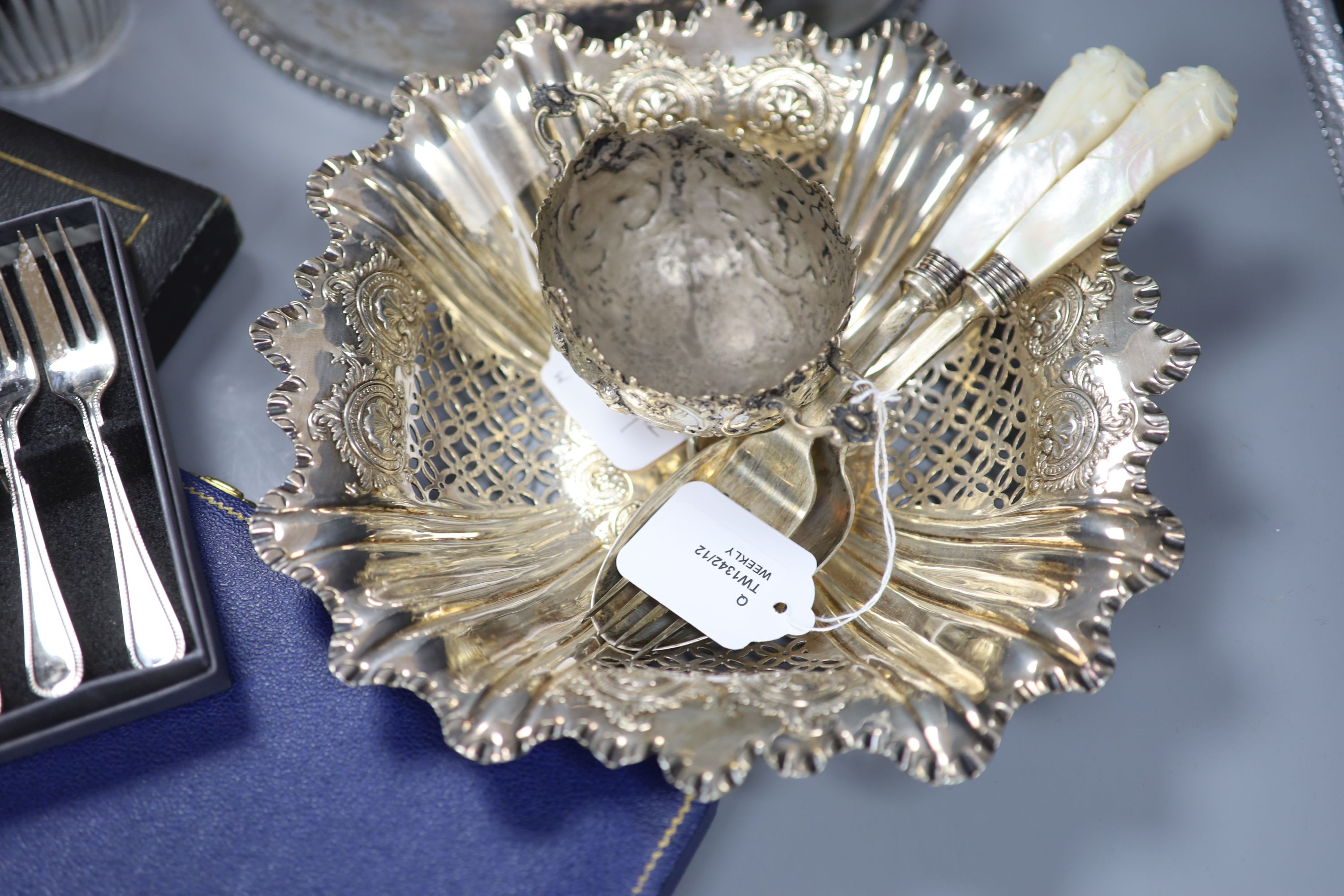 A cast white metal bowl and a collection of plated items, including a hot water pot, meat cover, cased flatware etc.